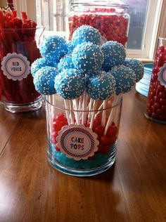 there are many red, white and blue lollipops in a glass on the table