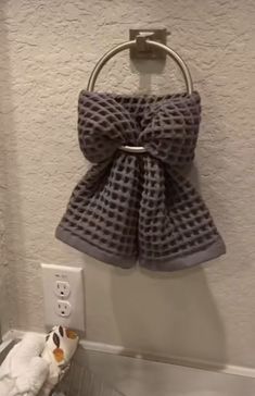 a towel hanging on the wall next to a sink with a stuffed animal in front of it