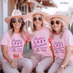 three women wearing matching pink shirts and hats