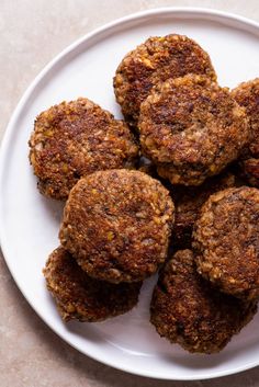 a white plate topped with meat patties on top of a table