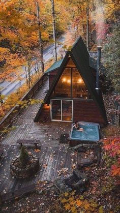 an aerial view of a cabin in the woods with a hot tub and fire pit