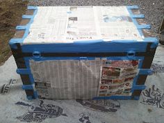 a large blue and black box sitting on top of a cement ground next to grass