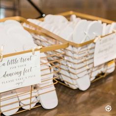 two baskets filled with white dishes on top of a wooden table next to a sign that says, a little treat for your dancing feet please take a seat