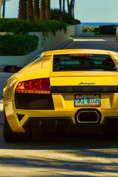 a yellow sports car is parked on the street