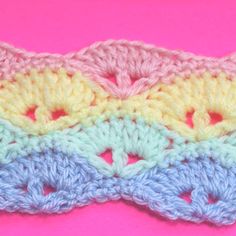 the crochet is multicolored and sits on a pink surface