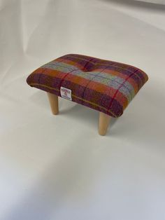 the foot stool is made out of plaid fabric