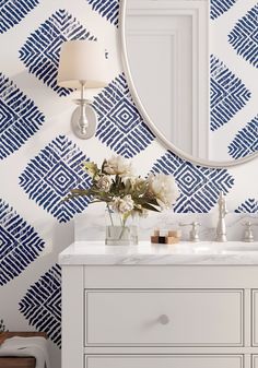 a bathroom vanity with blue and white wallpaper