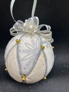 a white ornament with silver and gold beads