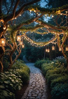 a pathway with lanterns hanging from the trees