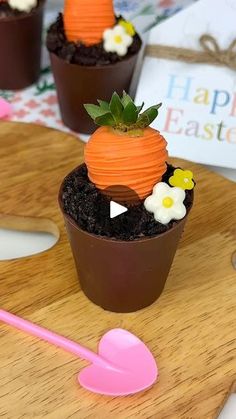 small potted plants with carrots and flowers in them sitting on a wooden cutting board