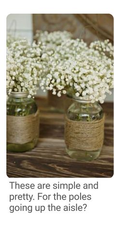 two vases filled with baby's breath flowers on top of a wooden table