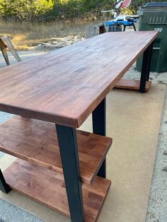 a wooden table sitting on top of a sidewalk