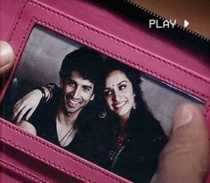 a man and woman are smiling in a pink wallet