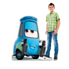 a young boy standing next to a toy car with eyes on it's side