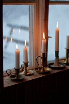 candles are lit in front of a window