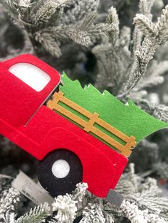 a red truck ornament hanging from a christmas tree