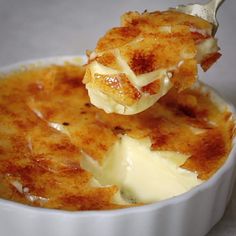 a close up of a spoonful of food in a white bowl on a table