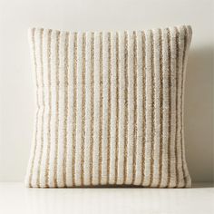 a white and beige striped pillow sitting on top of a table