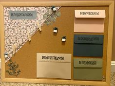 a cork board with several pieces of paper pinned to it and some magnets on them