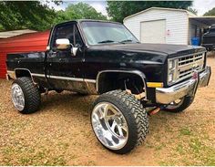 a black pickup truck parked on top of a dirt field