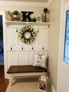 a white bench with a wreath on top of it next to a door and window