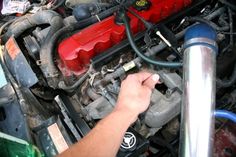 a man working on an engine in his car