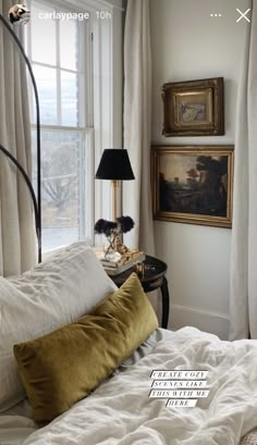 a bed with white sheets and pillows in front of a painting on the wall next to a window