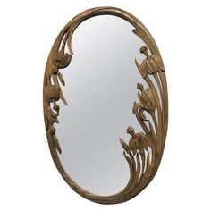 an oval mirror with flowers and leaves on it