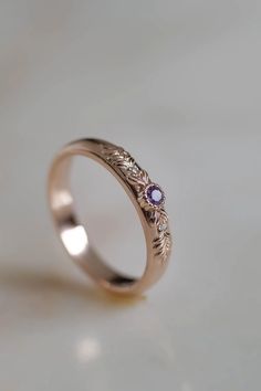 a close up of a wedding ring on a white surface with the light shining through it