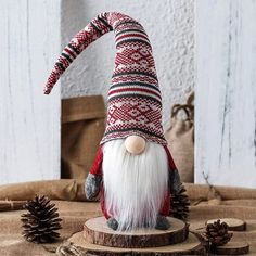 a gnome figurine sitting on top of a wooden table next to pine cones