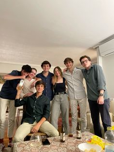 a group of people posing for a photo in front of a table with food and drinks