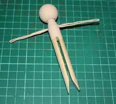 two wooden sticks sticking out of the top of a doll's body on a green cutting board