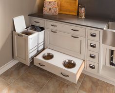 an open drawer in the kitchen with two bowls and one bowl on it's side