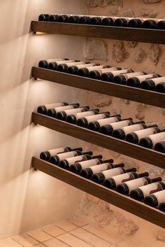 the wine bottles are lined up on the shelves in the room with no one around them