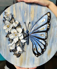 a person holding a plate with a butterfly and flowers on it