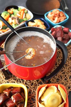 an assortment of food including meats, vegetables and soup in bowls on a table