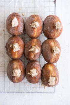 twelve donuts with peanut butter on top sitting on a cooling rack, ready to be eaten