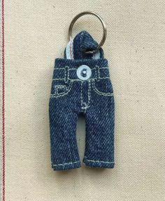 a pair of blue jeans hanging from a metal hook