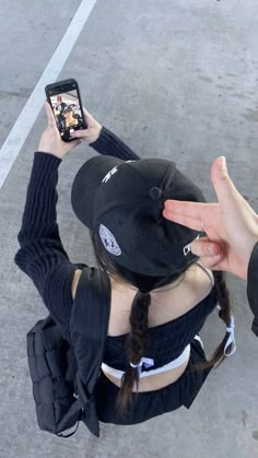 a person holding up their cell phone to take a selfie in the parking lot