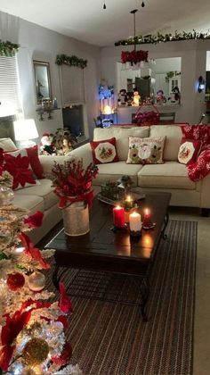 a living room decorated for christmas with red and white decorations on the couches, coffee table