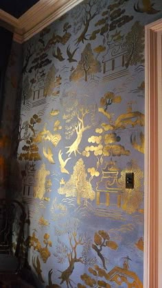 a room with blue and gold wallpaper on the walls