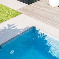 an empty swimming pool next to a wooden deck