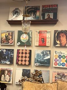 the wall is covered with various records and cds, including one that has a chandelier hanging from it