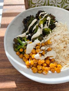 a white bowl filled with rice, broccoli and chickpeas