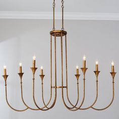 a gold chandelier with six candles hanging from it's center and four arms