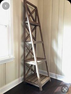 a ladder leaning against the wall in an empty room with wood floors and white walls