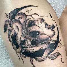 a woman's thigh with a black and white tattoo design on the side of her leg