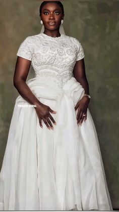 a woman in a white dress posing for a photo