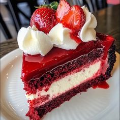 a piece of red velvet cake with whipped cream and strawberries on top