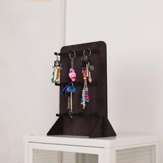 Wooden Keychain Holder with 9 Hooks | Freestanding Organizer | 10 Color Options Organize your keys with style using this beautifully crafted freestanding wooden keychain holder. Made from high-quality plywood, this compact yet spacious organizer features 9 durable hooks, perfect for keeping keys, lanyards, and small accessories tidy and accessible. Key Features: - Material: High-quality plywood with a smooth, polished finish. - Size: 11.9" x 7.9" x 5.5", perfect for countertops, shelves, or tabl Keychain Rack, Keychain Stand, Keychain Display, Keychain Holder, Wood Keychain, Wooden Keychain, Key Holders, Key Hook, Key Hooks